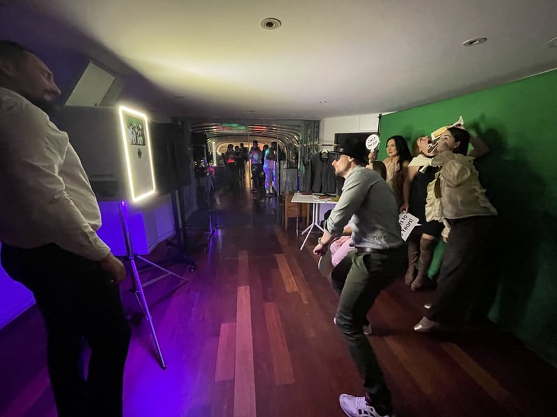 Hosté se fotí u greenscreenu ve fialovém světle večírku