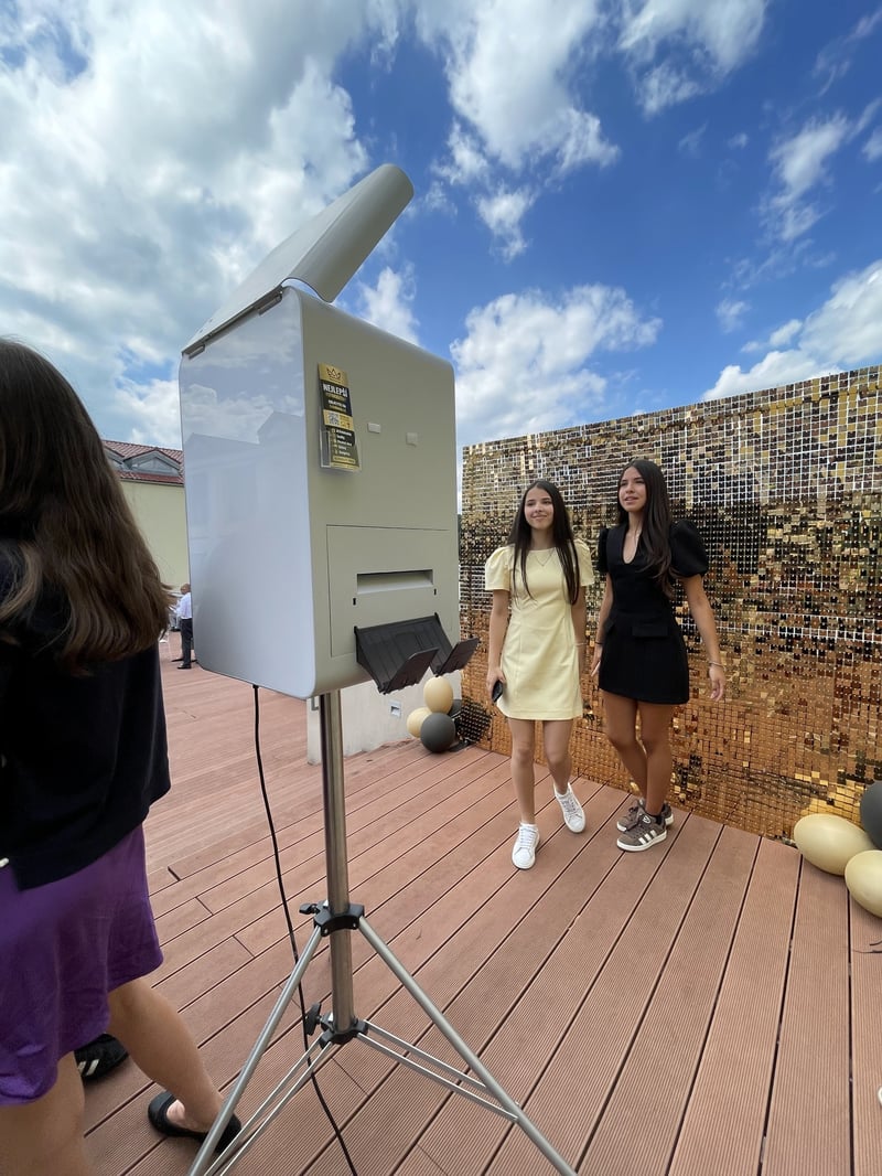 Fotobox von Fotoboss an einer goldenen Wand bei einer Abschlussfeier im Freien